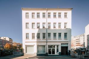 a white building on a city street at Luga Homes - Mitte in Leipzig