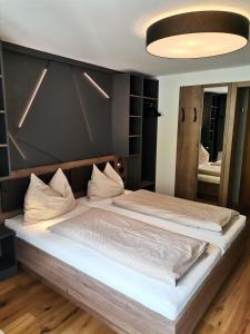 a bedroom with a large bed with a black wall at Haus Tuklar in Brand