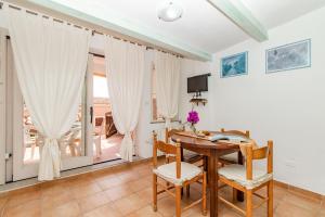 comedor con mesa de madera y sillas en Giorgio, en Capo Testa