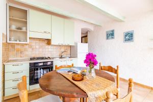 una cocina con una mesa de madera con flores rosas. en Giorgio, en Capo Testa