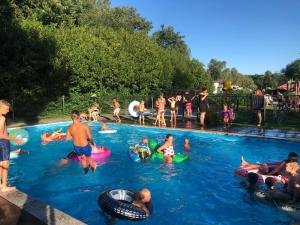 a group of people playing in a swimming pool at Stacaravan in De Pol