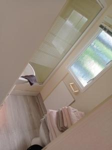 een kamer met een raam en handdoeken op een trap bij Stacaravan in De Pol
