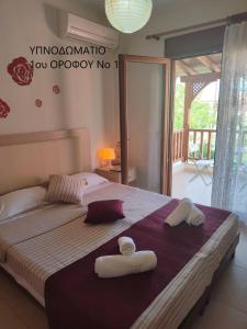 a bedroom with a large bed with towels on it at Maisonette In Paradisos in Neos Marmaras