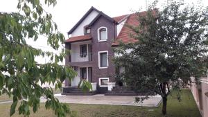 a large brick house with a tree in front of it at Vila Family in Cricova