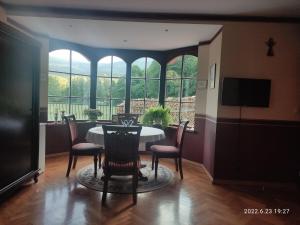 a dining room with a table and chairs and windows at Willa Leśna Polana in Szklarska Poręba