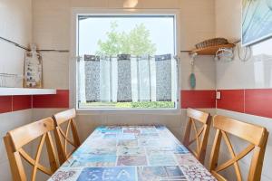a dining room table with two chairs and a window at Tide in Simonsberg