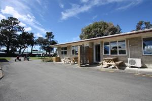 ein Gebäude mit Picknicktischen außerhalb des Gebäudes in der Unterkunft Waikanae Beach TOP 10 Holiday Park in Gisborne