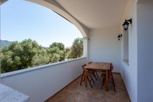 Padru的住宿－Casa Michela，阳台配有桌椅和窗户。