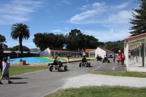 een groep mensen die op een motor door een straat rijden bij Waikanae Beach TOP 10 Holiday Park in Gisborne