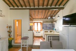 eine Küche mit einem weißen Kühlschrank und einem Tisch in der Unterkunft La Casina di Gigliola in Bibbona