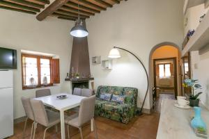 eine Küche und ein Wohnzimmer mit einem Tisch und einem Stuhl in der Unterkunft La Casina di Gigliola in Bibbona