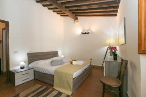 ein Schlafzimmer mit einem Bett und einem Stuhl in der Unterkunft La Casina di Gigliola in Bibbona