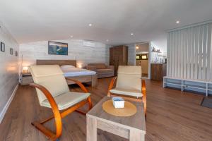 a room with a bed and two chairs and a table at Splav-apartman Grizzly in Gaočići