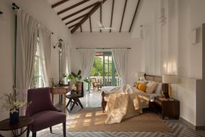 Marna的住宿－VianaarEscapes-Cardo-IndoPortuguese Villa-Assagao，卧室配有一张床和一张桌子及椅子