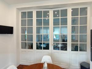 a large white cabinet with glass doors in a room at Gîte à la ferme Chez Magali in Cambrai