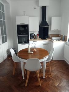 a kitchen with a wooden table and white cabinets at Gîte à la ferme Chez Magali in Cambrai