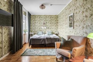 a bedroom with a bed and a couch and a chair at Hotell Nordevik in Skärhamn