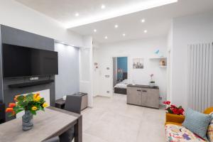 un soggiorno con una TV, un divano e un tavolo di LA DIMORA E IL REDENTORE a Bari