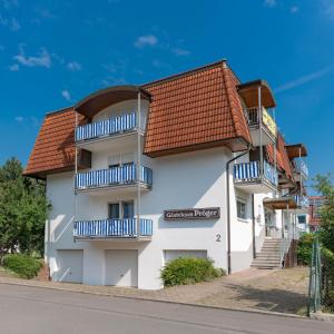 a white building with blue balconies on a street at Hotel Adler mit Gasthaus in Haßmersheim