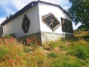 a white house with a cross on the side of it at Casa Montagnola: naturaleza y tranquilidad in Teotitlán del Valle