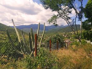 a fence in a field with mountains in the background at Casa Montagnola: naturaleza y tranquilidad in Teotitlán del Valle