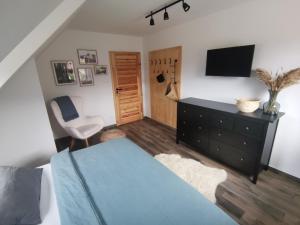 a bedroom with a bed and a tv and a chair at CHALUPA U ROUBÍČKŮ in Horní Bečva