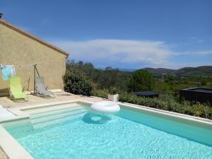 a swimming pool in front of a house at "Plus belle l'Ardèche" Studio de jardin et piscine in Vinezac