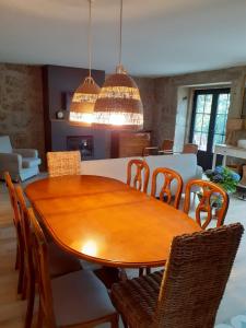 uma sala de jantar com uma mesa de madeira e cadeiras em Villa Dos Santos - Gerês Country House no Gerês