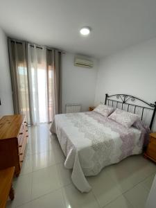 a bedroom with a bed and a dresser and window at Atico HouseGom in Cazorla