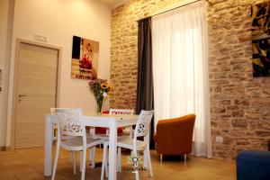 una sala da pranzo con tavolo e sedie bianchi di Casa degli Amici a Ruvo di Puglia