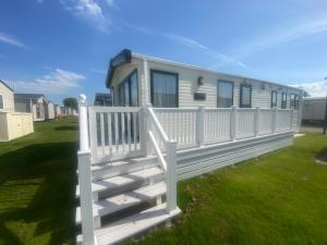 a white fence in front of a mobile home at Winchelsea Beach Holiday Home - Pool & Beach in Winchelsea