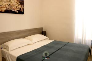 a small bedroom with a bed with a blue blanket at Casa degli Amici in Ruvo di Puglia +10 photos