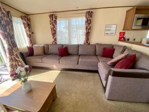 a living room with a gray couch and red pillows at Winchelsea Beach Holiday Home - Pool & Beach in Winchelsea