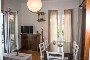 una sala da pranzo con tavolo, sedie e televisione di Platyforos, in city central of Zakynthos a Città di Zante