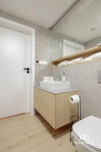 un baño con lavabo y espejo en Apartament Baltic Blues z dostępem do basenów,strefy saun,jacuzzi - Pinea Apartments Pobierowo - SANNEL Apartments for rent, en Pobierowo