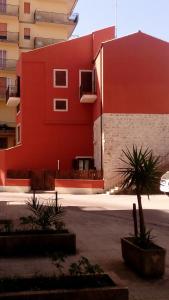 モーディカにあるLa Casa di Petraの目の前に植物が植えられた赤い建物