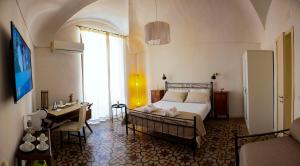 ein Schlafzimmer mit einem Bett und einem Schreibtisch in einem Zimmer in der Unterkunft Jasper B&B in Catania