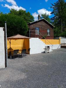 een patio met een tafel en stoelen en een gebouw bij Chalet du Sanglier in Rancennes