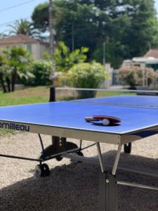 una mesa de ping pong con una pelota de ping pong. en Motel Esterel en Mandelieu-la-Napoule