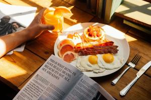 een bord met ontbijtproducten op een tafel met een boek bij Kings Palace in Belgrado