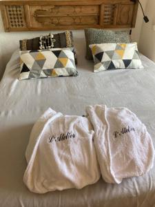 two white towels sitting on top of a bed at L’Atelier in La Garonnette-Plage