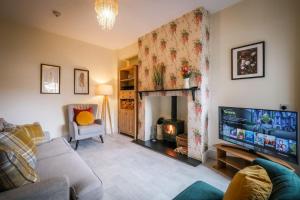 a living room with a television and a fireplace at Glen Wynne Apartment Lovely Central Pet Friendly - FREE off-site Health Club access with Pool, Sauna, Steam Room & Gym in Windermere