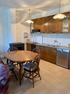 a kitchen with a wooden table and chairs and a sink at Apartmani Luka in Korčula