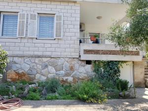 a house with a stone wall and a window at Apartmani Luka in Korčula