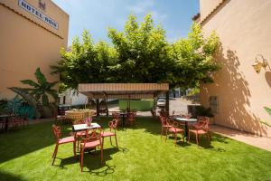 a patio with tables and chairs on the grass at Hotel ROIG in Benasal