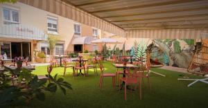 a patio with tables and chairs on the grass at Hotel ROIG in Benasal +42 photos