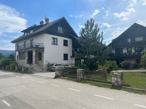 una casa blanca al lado de una carretera en Apartmaji Iva, en Bled