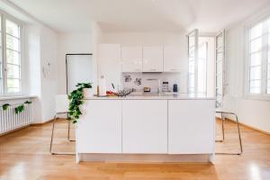 una cocina blanca con armarios blancos y ventanas en Esclusivo appartamento storico a ☆☆☆☆☆ - BELLINZONA, en Bellinzona