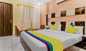 a bedroom with a large bed with a rainbow bedspread at Itsy By Treebo - Royal Residency in Chandīgarh