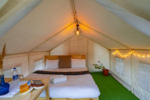 レーにあるBikamp Camp Leh Ladakhのテント内のベッドルーム(ベッド1台、テーブル付)